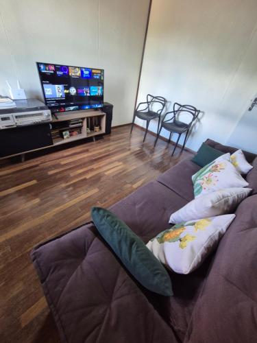 a living room with a couch and a tv at Casa completa in Caçapava do Sul