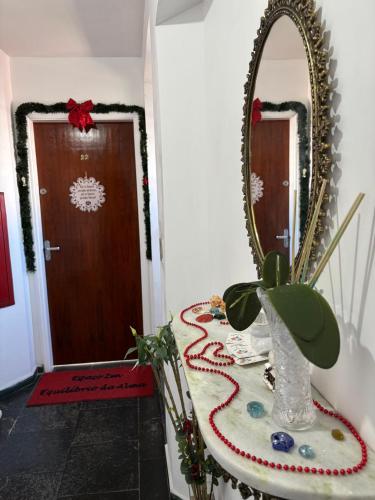 a room with a table with a mirror and a plant at Espaço Zen - Equilíbrio da Alma in Guarujá