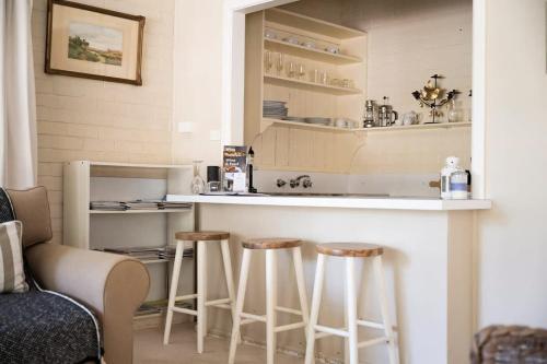 a kitchen with two stools and a bar in a room at Stunning Garden Studio at Mayfield Vineyard in Bloomfield