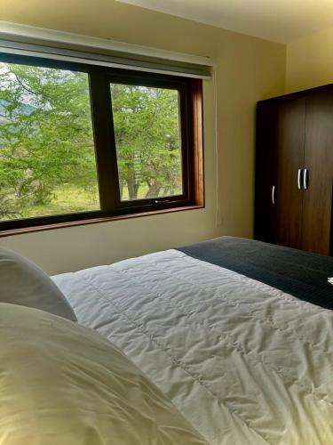 a bedroom with a large bed and a window at Cabañas Raíces de la Patagonia in Coihaique