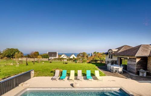 a backyard with a pool and chairs and a house at Lovely Home In Lanvéoc in Lanvéoc