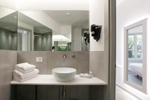 ein Badezimmer mit Waschbecken und Spiegel in der Unterkunft The Grove in Mailand