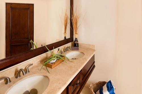 a bathroom with two sinks and a large mirror at Apartamento en Los Cabos - Misiones del Cabo in Cabo San Lucas