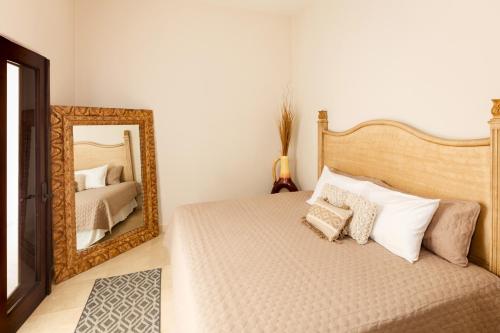 a bedroom with a bed and a mirror at Apartamento en Los Cabos - Misiones del Cabo in Cabo San Lucas