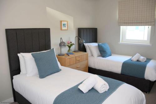 a bedroom with two beds with blue and white at 6 Zetland Road, Kirkwall, Orkney - OR00275F in Kirkwall