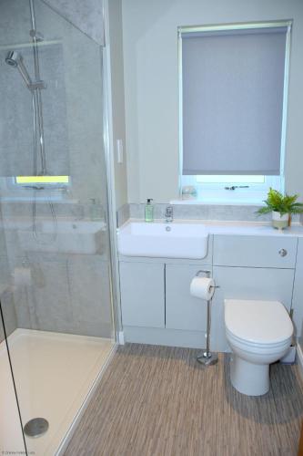 a bathroom with a shower and a toilet and a sink at 6 Zetland Road, Kirkwall, Orkney - OR00275F in Kirkwall