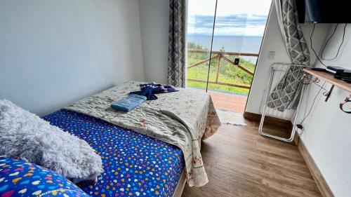 a room with a bed and a window with a view at Village as casinhas in Uruçuca