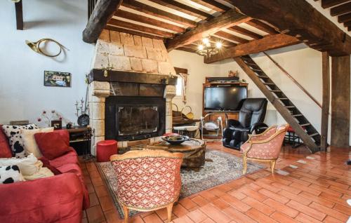 a living room with a fireplace and a couch and chairs at Maison Avec Piscine Couverte in Fervaques
