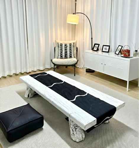 a room with a bed and a chair and a dresser at Zen House Suwon Hwaseong in Suwon