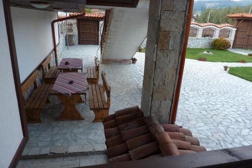 a view of a patio with benches and a table at Guest House H Dzhogolanov in Koprivshtitsa