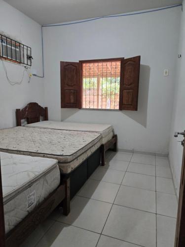 a bedroom with two beds and a window at Marahu Lindinhos in Belém
