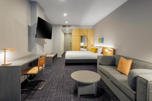 a hotel room with a bed and a couch at lyf on Elizabeth Melbourne in Melbourne