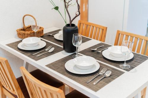 a dining table with plates and silverware on it at GJbb 小岩駅から徒歩6分 羽田空港成田空港行きの直行バス 子連れ in Tokyo