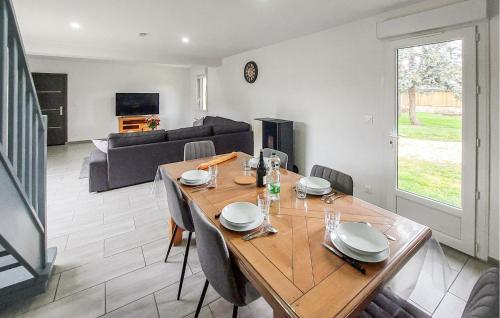 a dining room and living room with a wooden table at Authentique Ferme En Campagne in Saint-Germer-de-Fly