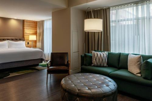 a hotel room with a bed and a green couch at Renaissance Allentown Hotel in Allentown