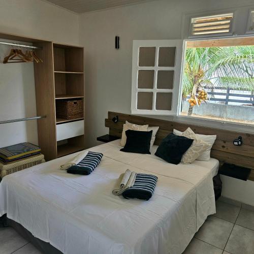 a bedroom with a large white bed with a window at Charmante villa bord de mer les pieds dans l'eau in La Trinité