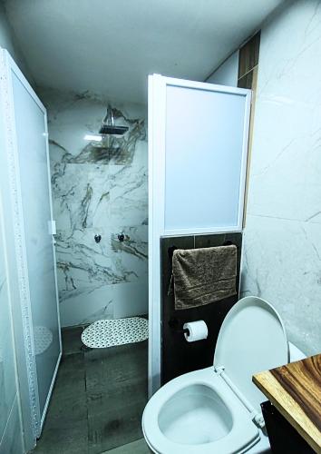 a white bathroom with a toilet and a shower at Casona Imperial in Tepic