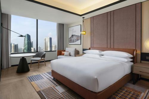 a bedroom with a large white bed and a desk at Sheraton Johor Bahru in Johor Bahru