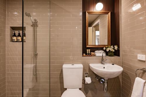 a bathroom with a toilet and a sink and a shower at Hadley's Orient Hotel in Hobart