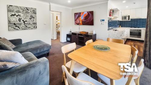 a kitchen and living room with a table and a couch at Mowamba D4 in Thredbo