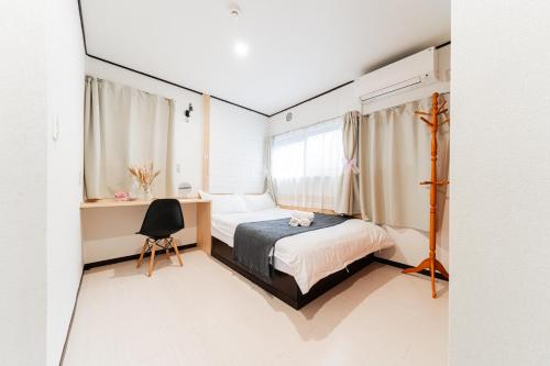 a bedroom with a bed and a desk and a window at GJbb 小岩駅から徒歩6分 羽田空港成田空港行きの直行バス 子連れ in Tokyo