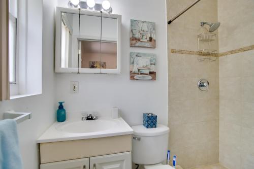a white bathroom with a sink and a shower at 2 Mi to Boardwalk Home with Grill in Dania Beach! in Dania Beach