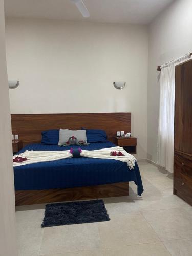 a bedroom with a blue bed with a wooden headboard at Casa Maria Bonita in Troncones