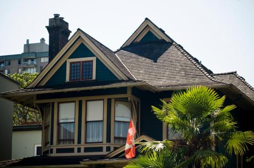 a blue house with a flag in front of it at O Canada House Bed & Breakfast in Vancouver