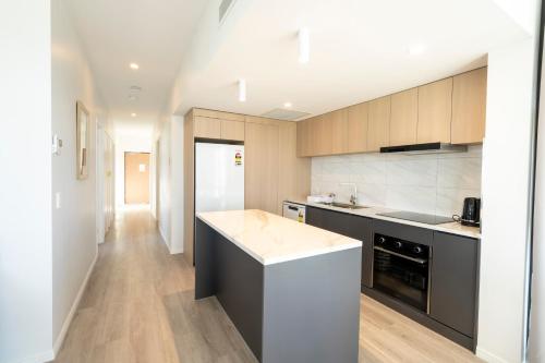 a kitchen with wooden cabinets and a counter top at Boutique Apartments Southport in Gold Coast