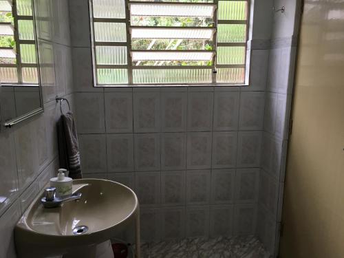 a bathroom with a sink and a window at um pedaço do paraíso in São Roque