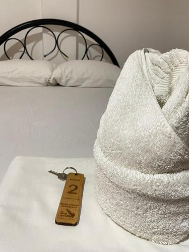 a towel on a bed with a tag on it at Alona Chrisah Apartelle in Panglao Island