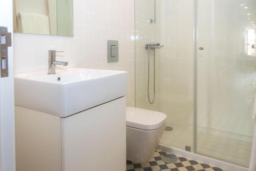 a white bathroom with a sink and a shower at Liiiving in Porto | Central Garden Flat in Porto