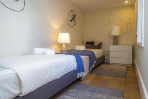 a bedroom with two beds and a clock on the wall at Liiiving in Porto | Central Garden Flat in Porto