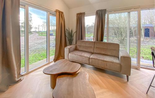 a living room with a couch and a table and windows at Sernets Recreatie Chalet 111 in Oud-Gastel