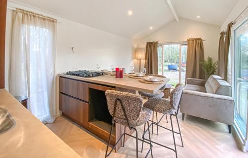 a kitchen with a counter and a table with chairs at Sernets Recreatie Chalet 111 in Oud-Gastel