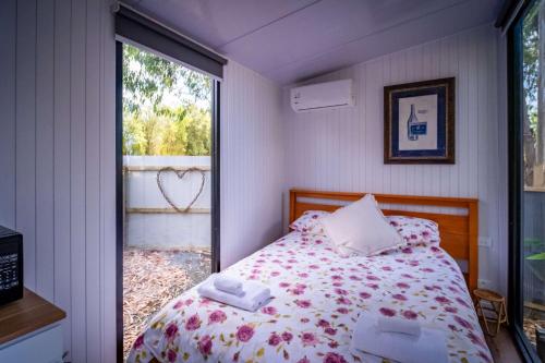 a bedroom with a bed and a window at The Hide Away Cabin by Tiny Away in Redwoods Valley
