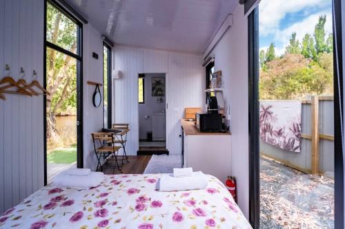 a bedroom with a bed in a room with a window at The Hide Away Cabin by Tiny Away in Redwoods Valley