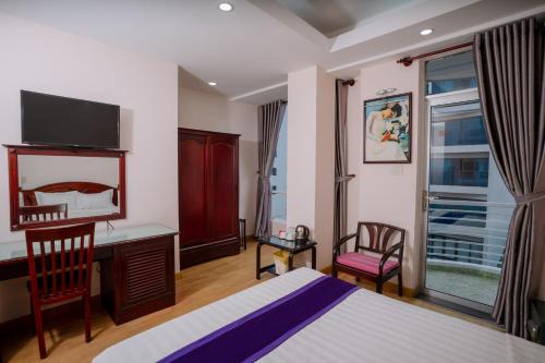 a hotel room with a bed and a desk and a window at Violet hotel&spa in Nha Trang