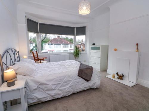 a bedroom with a large white bed and a window at Broadgreen in Liverpool
