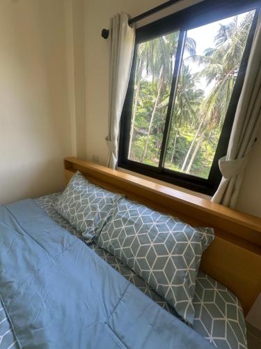 a bed in a room with a window at Mina House in Thong Nai Pan Yai