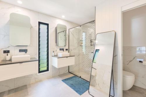 a bathroom with a shower and a sink and a toilet at Palmy Villa in Gold Coast