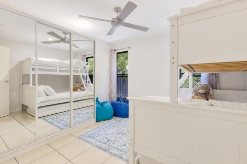 a room with two bunk beds and a ceiling fan at Palmy Villa in Gold Coast