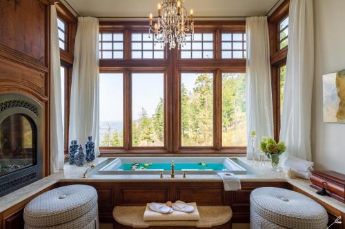 a bathroom with a tub with a fireplace and a chandelier at Chateau Okanagan in Kelowna
