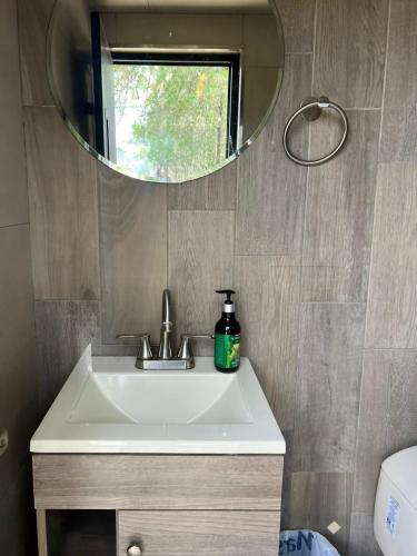 a bathroom with a sink and a mirror at Cabaña El real in Cedro