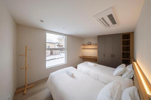 a bedroom with two beds and a window at Sakuraya in Hakuba