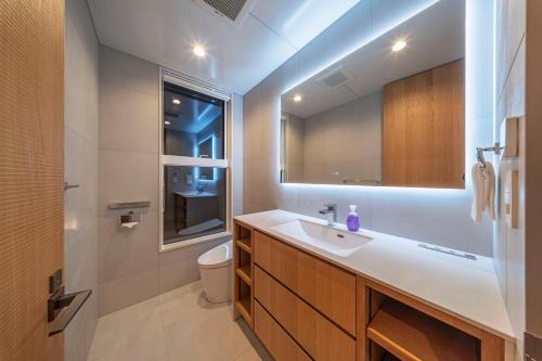 a bathroom with a sink and a toilet and a mirror at Sakuraya in Hakuba