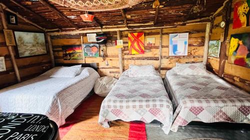 a room with two beds in a wooden room at Cabaña Rústica Villa Alicia in Paipa