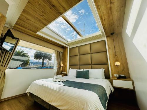 ein Schlafzimmer mit einem Bett und einem großen Fenster in der Unterkunft Hotel Shalom in Riobamba