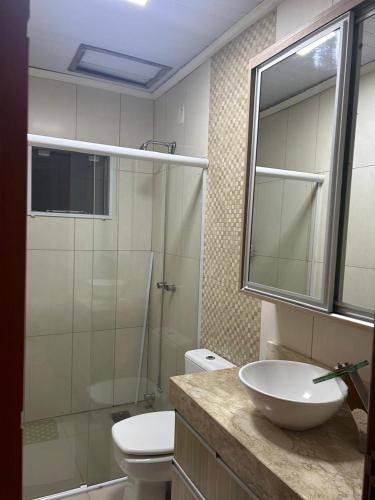 a bathroom with a sink and a toilet and a shower at Casa de lazer e tranquilidade in Tramandaí