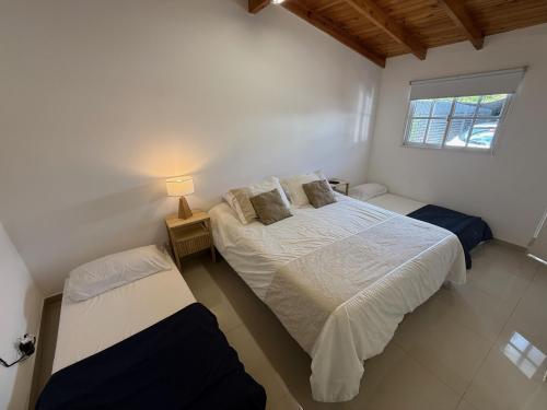 a bedroom with two beds and a window at Cocheras Ezeiza Victoria in Ezeiza